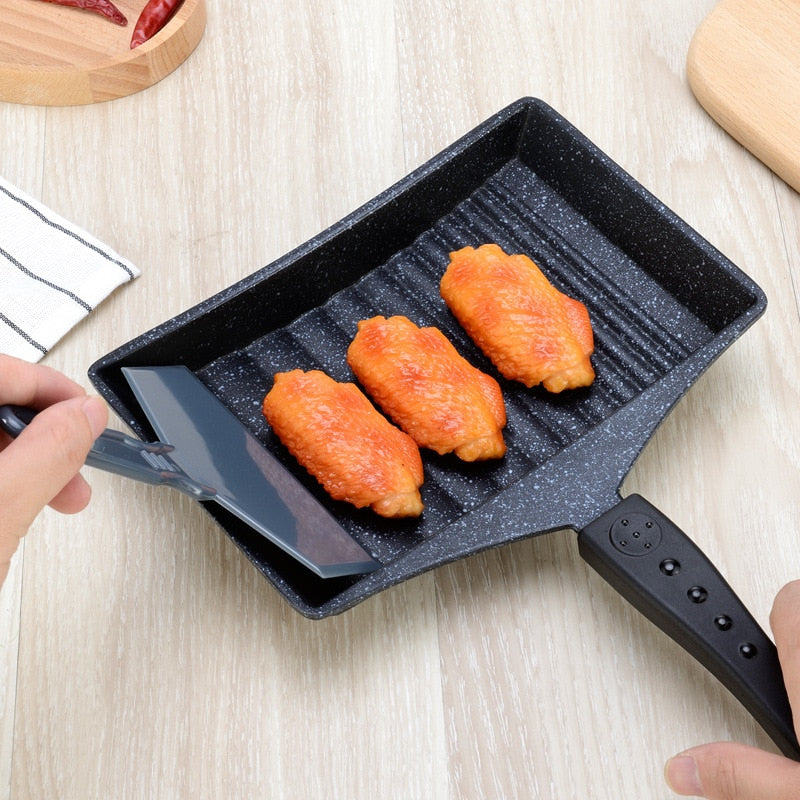 Non-Stick Wave Bottom Tamagoyaki Omelette Saucepan with cooked chicken wings on wooden surface