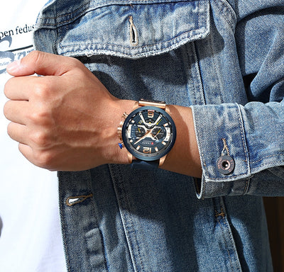 Military chronograph leather watch with black dial worn on wrist with denim jacket