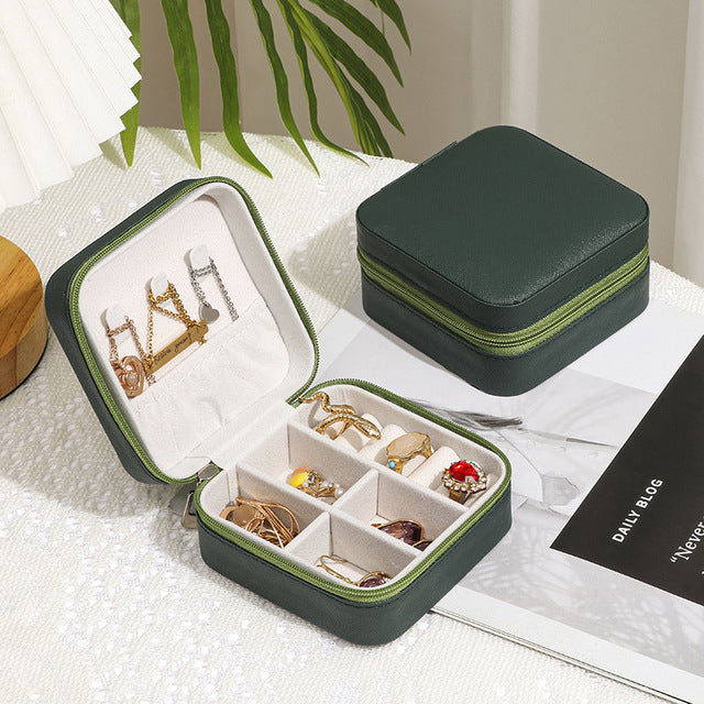 Jewelry Zipper Box Storage in dark green with multiple compartments holding rings and earrings