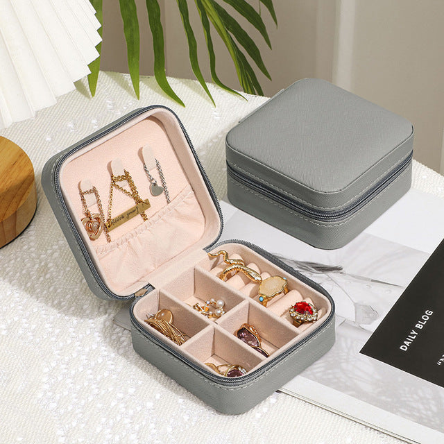 Gray Jewelry Zipper Box Storage with multiple compartments holding rings and necklaces