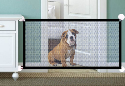 Portable pet safety gate installed between furniture with a bulldog sitting behind it