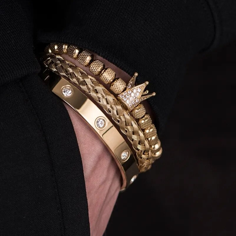 Gold tone stainless steel Roman bracelets featuring a crown charm and crystal accents on wrist