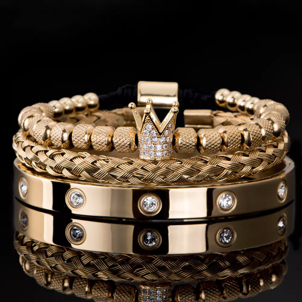Gold stainless steel Roman bracelets set with crown charm and crystal accents on black background