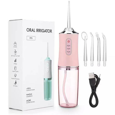 Pink waterproof dental irrigator with four interchangeable nozzles and USB charging cable next to product box