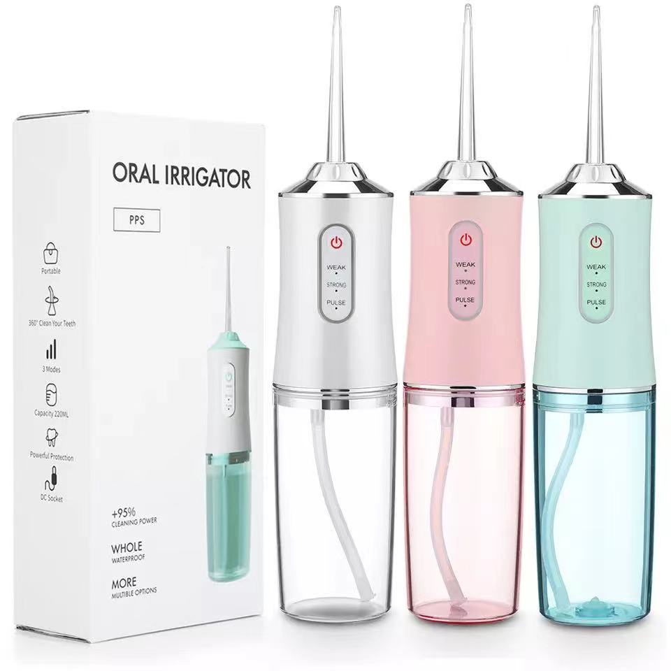 Waterproof dental irrigator in white pink and blue with clear water tanks and power buttons